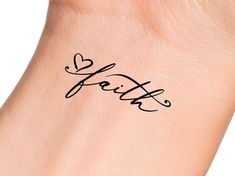 a woman's wrist with the word faith written in cursive writing