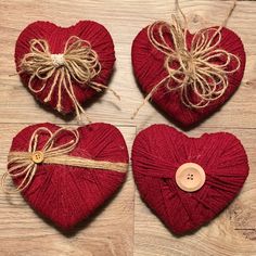 three red heart shaped ornaments tied with twine and burlap, on a wooden surface