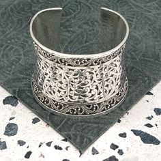 Indulge In The Timeless Elegance Of This Lois Hill Statement Cuff Bracelet. The Center Section Proudly Showcases Lois Hill's Signature Scroll Design, While The Borders Are Adorned With The Intricate Granulated Pattern. The Cuff Edges, Border, And Entire Backside Are All Hammered. Stamped With "Lois Hill" And A Floral Logo Above It At The Center Back, This Bracelet Embodies Authenticity And Artistry. With An Inside Measurement Of Nearly 5.75" And A Gap Of 1.25", The Total Inside Circumference Spans Nearly 7". The Width At The Widest Point, Measured From The Back, Is Just Over 2.125". With A Total Weight Of 123 Grams, This Bracelet Is A Wearable Masterpiece. Product Details: Decade: 20 Classic Adjustable Cuff Bracelet With Intricate Design, Classic Formal Cuff Bracelet With Intricate Design, Classic Intricate Cuff Bracelet For Formal Occasions, Luxury Wide Band Cuff Bracelet As Gift, Luxury Wide Band Cuff Bracelet Gift, Luxury Silver Open Cuff Bracelets, Luxury Open Band Cuff Bracelet As Gift, Luxury Open Band Cuff Bracelet For Gift, Luxury Wide Band Bangle