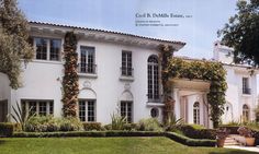 a large white house with lots of windows and ivy growing on the side of it