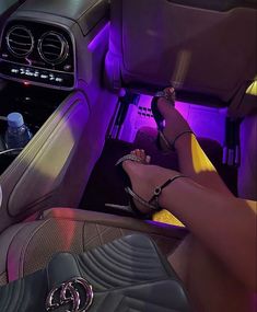 a woman's feet in high heeled sandals sitting on the front seat of a car