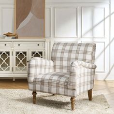 a living room with a plaid chair and sideboard