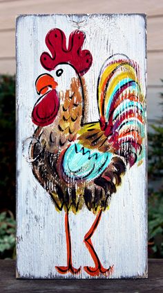 a rooster painted on a white wooden sign