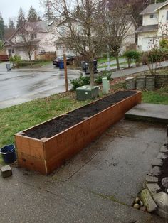 a large wooden planter filled with dirt