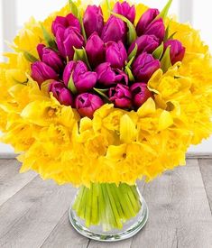 a vase filled with purple and yellow flowers