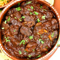 a bowl filled with meat and garnished with cilantro on the side