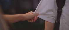 two people are shaking hands with each other while wearing white shirts and black suspenders