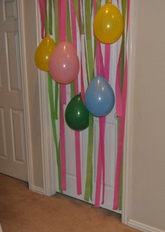 balloons hanging from the ceiling in front of a door