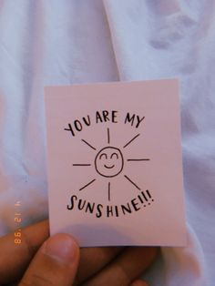 someone holding up a piece of paper with the words you are my sunshine on it