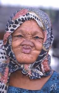 an old woman with blue and white polka dots on her head is making a funny face