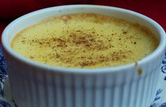 a white bowl filled with food on top of a blue and white saucer next to a red cloth