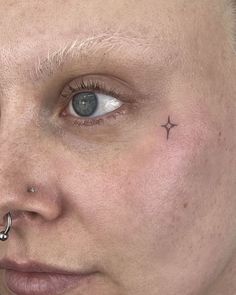 a close up of a person with piercings on her nose and nose ring in front of their face