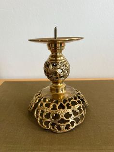 an ornate brass candle holder on a table