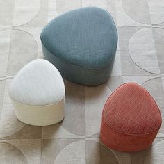 three different colored stools sitting on top of a floor next to eachother