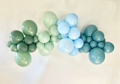 several balloons are arranged on a white surface with blue and green ones in the middle