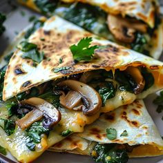 two quesadillas stacked on top of each other with mushrooms and spinach