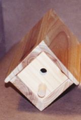 a wooden birdhouse with a hole in the middle