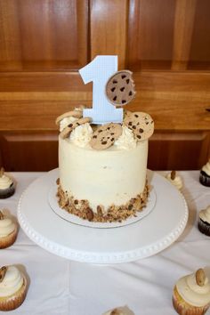 a birthday cake with cookies on it and the number one frosted in icing