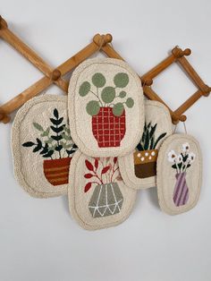 four pot holders with plants on them hanging from a wall