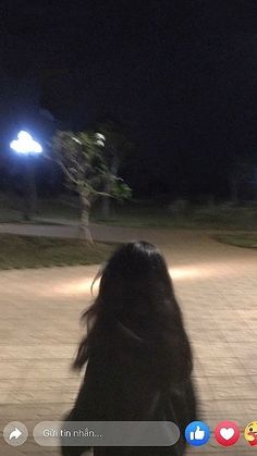 a blurry photo of a person standing in front of a street light at night