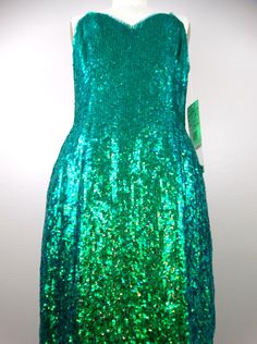 "The color of this one is ELECTRIC! It's fully embellished with iridescent mermaid green sequins all over! It's in perfect condition with the original retail tags still attached and also comes with a small bag of matching embellishments. ABSOLUTELY AMAZING! Bust - 36\" Waist - 28\" Hips - 38\" Length - 35\" Tag Size - 6 This dress comes from a pet-free and smoke-free home. If you would like more info or have any questions, please don't hesitate to ask!" Prom Season Mermaid Sequin Dress, Fitted Green Sequin Dress For Wedding, Green Glitter Fitted Dress, Glamorous Green Sequin Prom Dress, Glamorous Green Sequin Dress For Prom Season, Glamorous Green Sequin Dress For Prom, Fitted Green Glitter Dress, Green Fitted Dress With Glitter Details, Green Sequined Holiday Dress