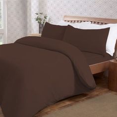 a bed with brown sheets and pillows in a room