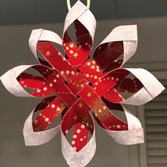 a red and white paper ornament hanging from a ceiling fixture in a room