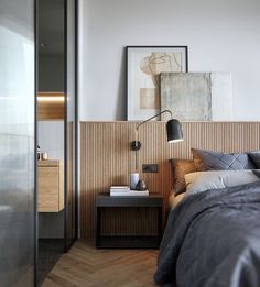 a bed sitting next to a wooden wall in a bedroom on top of a hard wood floor