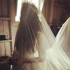 a woman in a wedding dress with a veil over her head