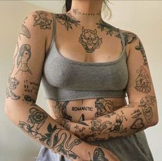 a woman with lots of tattoos on her arm and chest is posing for the camera