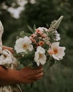 a woman holding a bouquet of flowers in her hands