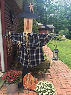 a scarecrow is sitting on the front porch