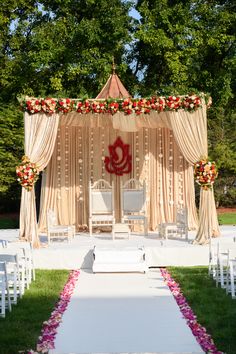 an outdoor ceremony setup with white chairs and flowers