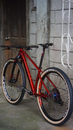 a red bike parked in front of a brick building