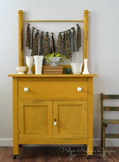 an old dresser is painted yellow and has some decorations on it