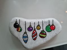 a rock with christmas ornaments hanging from it