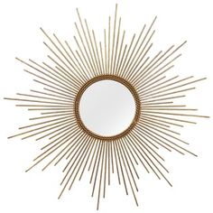 a gold sunburst mirror on a white wall