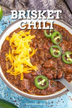 a bowl filled with chili, cheese and green peppers