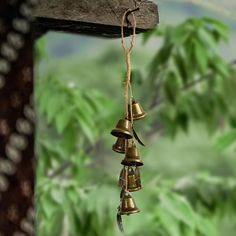 three bells hanging from the side of a wooden pole