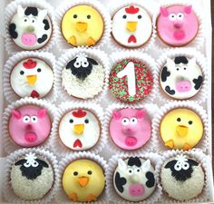 cupcakes decorated with farm animals and farm animals are arranged in a white box