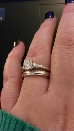 a woman's hand with two rings on it