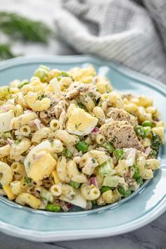 a plate full of pasta salad with meat and vegetables on it, ready to be eaten