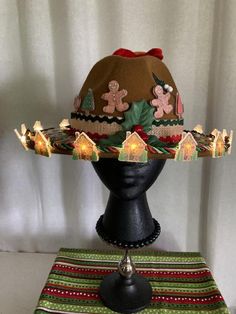 a brown hat with gingerbreads on it sitting on top of a black head