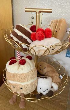 three tiered tray holding stuffed animals and cakes