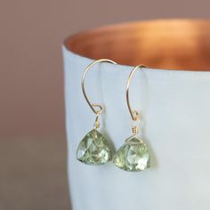 These delicate and elegant earrings feature very high quality green amethyst. Green amethyst is also known as prasiolite. The pyramid-shaped gemstones in a light green are absolutely free of inclusions (AAA+) and very finely cut. This gemstone stands for healing and balance. It is also the birthstone of the zodiac sign Pisces. Wear the fine hanging earrings with the green stones in your everyday life, for special moments or give them as a birthday present to your partner, best friend or mother. Faceted May Birthstone Earrings Gift, Green Amethyst Gemstone Earrings, Elegant Green Amethyst Earrings For Gift, Green Amethyst Dangle Earrings For Gift, Green Amethyst Dangle Earrings As Gift, Green Amethyst Jewelry For May Birthstone Gift, Elegant Gold Earrings With Green Amethyst, Faceted Green Amethyst Earrings Gift, Green Amethyst Dangle Jewelry Gift