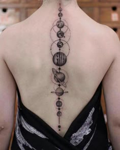 the back of a woman's neck with planets on it