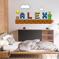 a bed room with a neatly made bed and mario wall decal on the wall