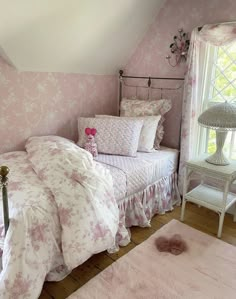 a bedroom with pink wallpaper and white bedding, including a pink teddy bear