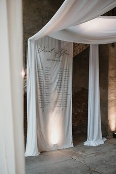 a wedding ceremony setup with white draping on the wall and table cloth draped over it