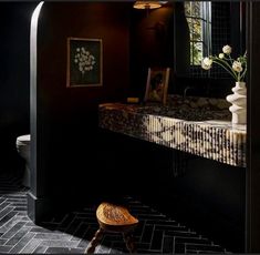 a bathroom with a sink, mirror and stool in it